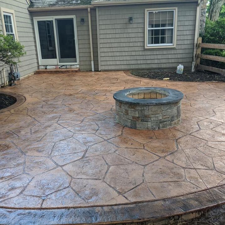 Backyard stamped concrete patio with a brick fireplace